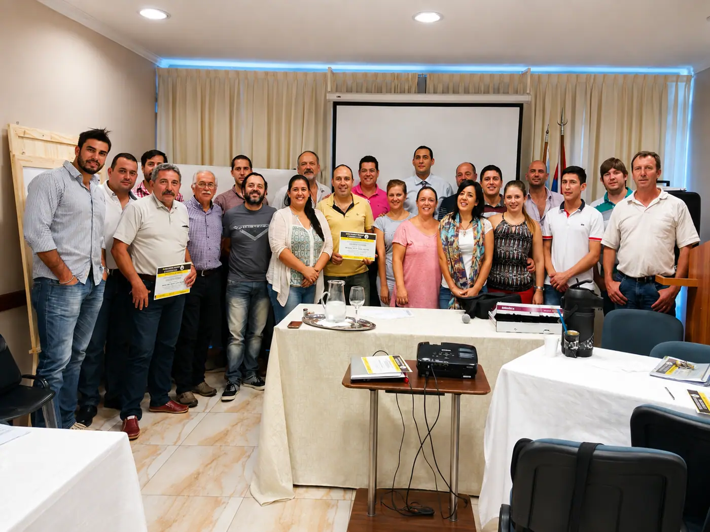 Grupo de asistentes con sus certificados al finalizar una capacitación